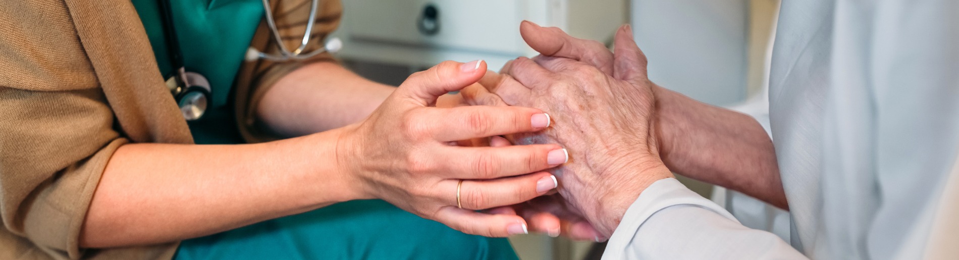 Nurse holding elderly persons hands